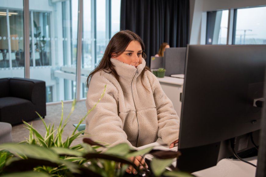 En kvinna i tjock tröja fryser på jobbet.