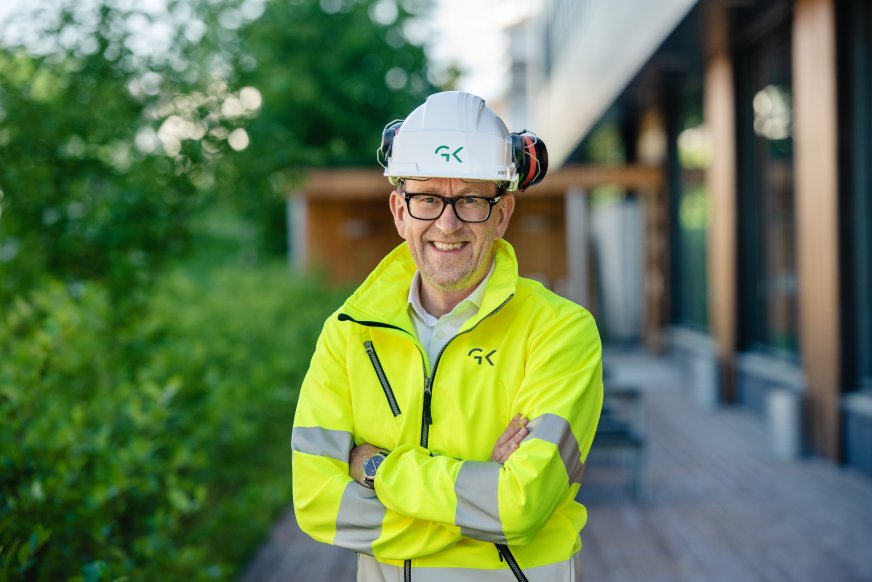 Bilde av Kim Robert Lisø, koncernchef i GK, utanfor Miljøhuset Ryen i arbeidstøy och hjelm.