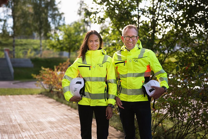 Bild på Martine Drevvatne, HSE-direktör, och Kim Robert Lisø, koncernchef på GK, med arbetskläder och en skyddshjälm i handen. Bild på Martine Drevvatne, HSE-direktör, och Kim Robert Lisø, koncernchef på GK, med arbetskläder och en skyddshjälm i handen.
