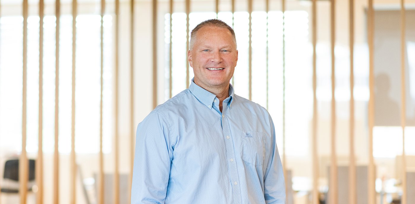 Porträttbild av Ronny Lindås, koncernchef för IT och digitalisering på GK, tagen inomhus framför en ribbvägg. Porträttbild av Ronny Lindås, koncernchef för IT och digitalisering på GK, tagen inomhus framför en ribbvägg.