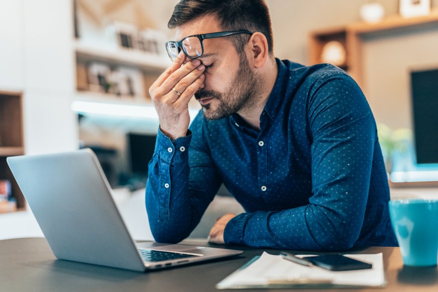 Man med glasögon vid skrivbord