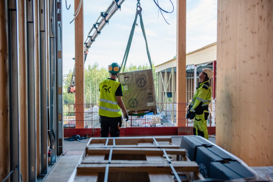 Två byggarbetare i varselvästar på byggarbetsplats.