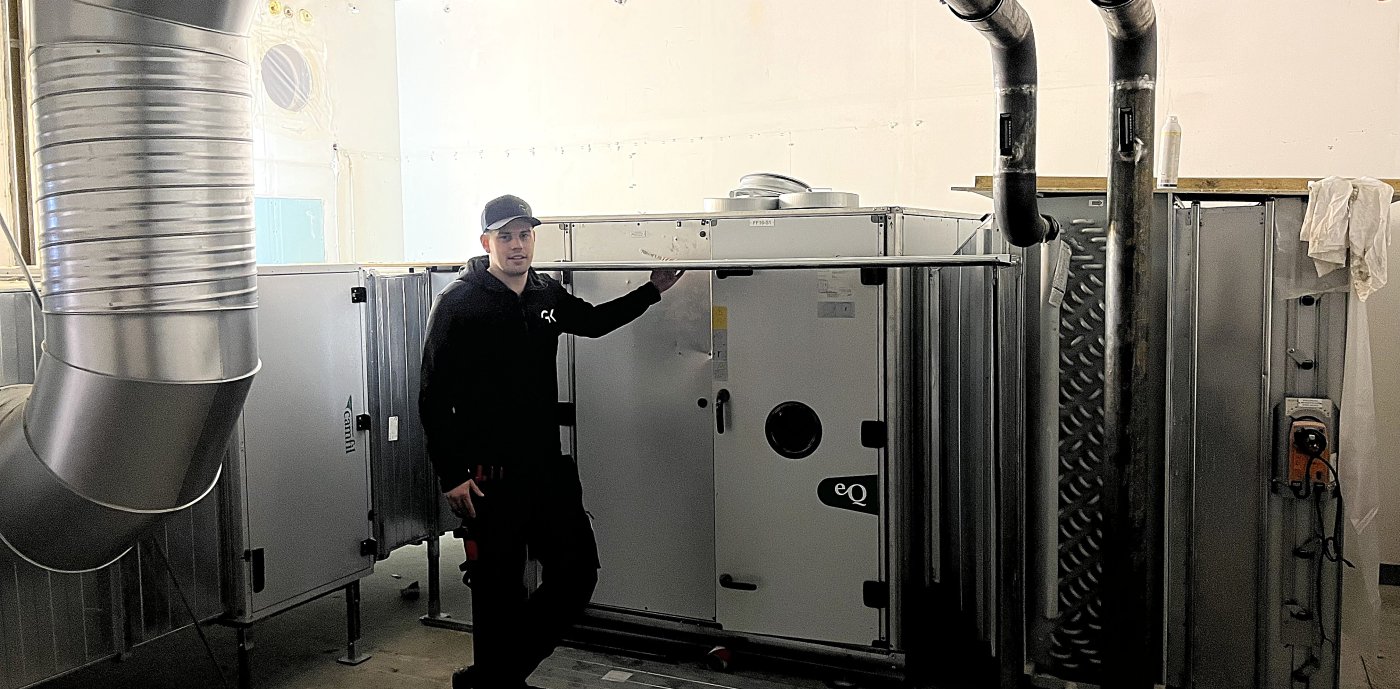 Man i svarta kläder står i ett fläktrum.