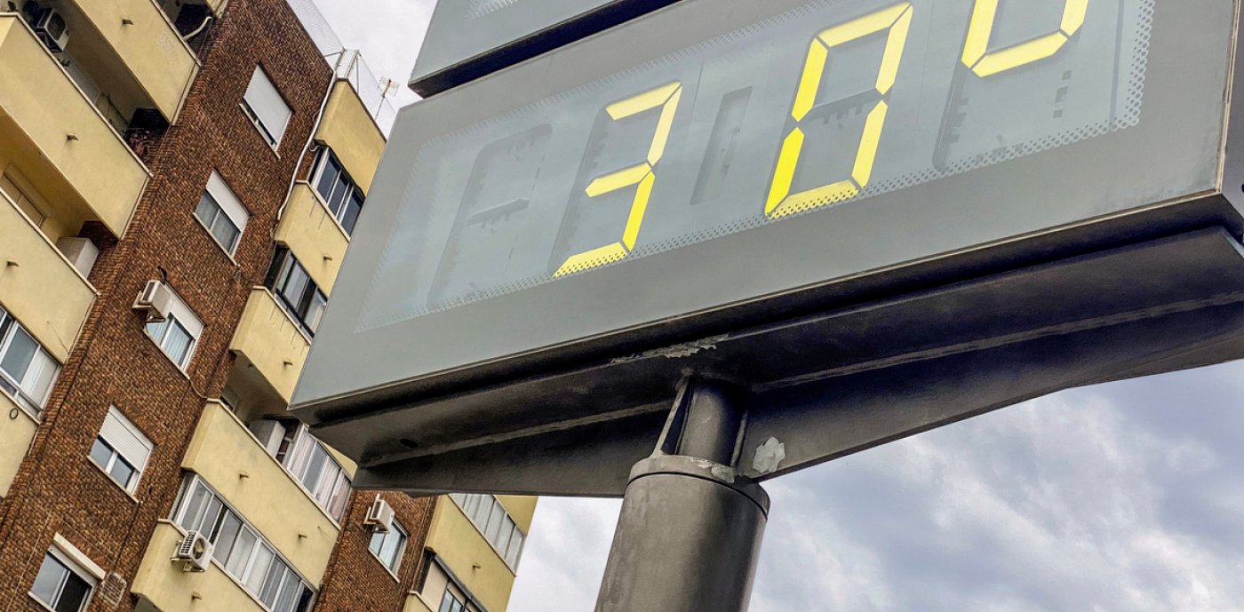 Temperaturskylt 30 grader med byggnad i bakgrunden
