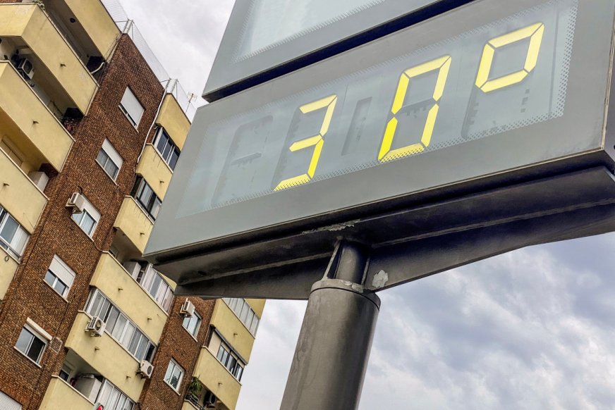 Temperaturskylt 30 grader med byggnad i bakgrunden