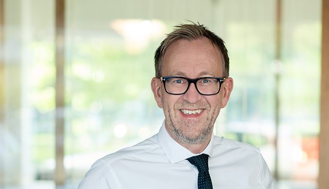 Bilde av konsernsjef i GK Kim Robert Lisø stående i et åpent kontorlandskap Bilde av konsernsjef i GK Kim Robert Lisø stående i et åpent kontorlandskap