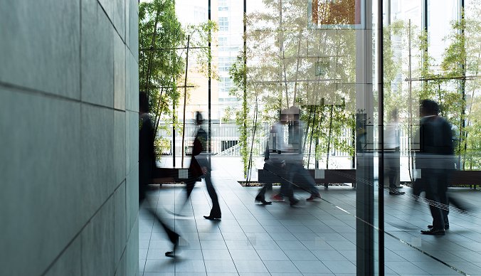 Et fellesareal med mange mennesker som går forbi  - sammen eller alene. Grønne planter og godt inneklima. Et fellesareal med mange mennesker som går forbi  - sammen eller alene. Grønne planter og godt inneklima.